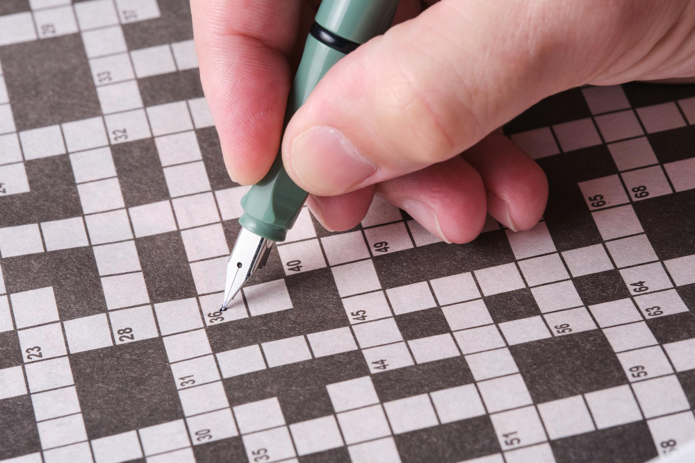 Pessoa resolvendo um jogo de palavras cruzadas, uma ótima opção de games para aprender inglês.