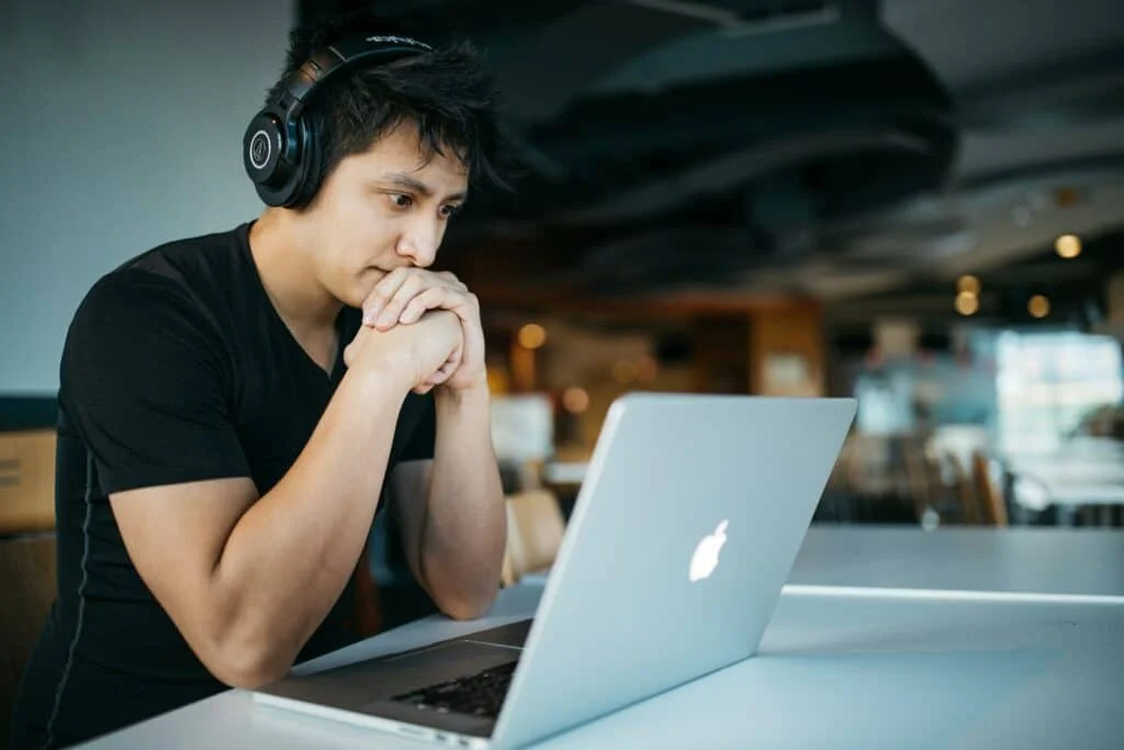 Foto de um homem preocupado em frente ao seu notebook.