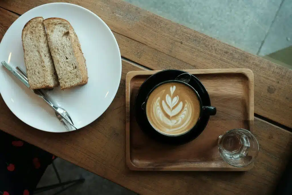 Foto de um café da manhã com pão e café com leite.