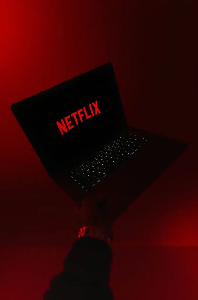 Foto de alguém segurando um notebook com a logo da Netflix.

Diferença entre in, on, e at.